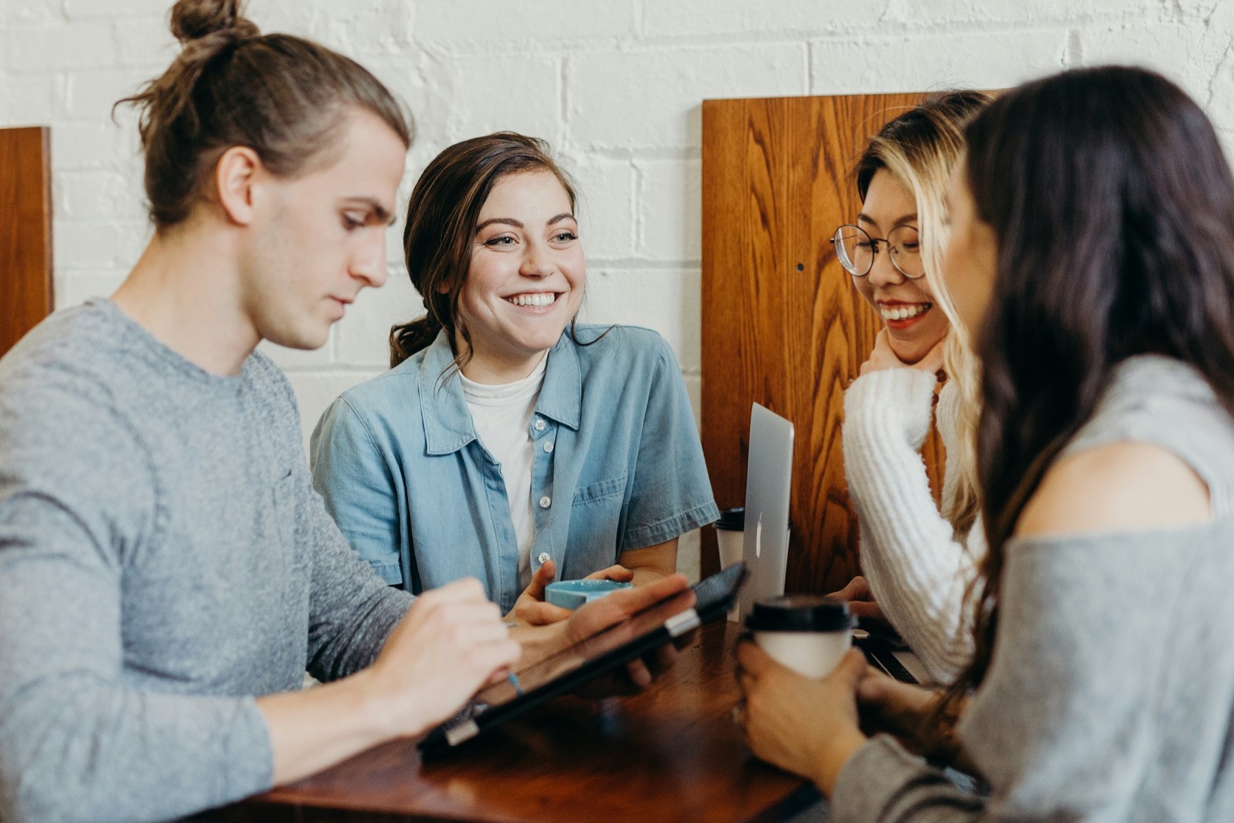 Four people talking together in warm light, two of them smiling